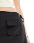 Lioness tie side skort with pocket detail in black