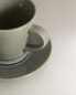 Glazed stoneware teacup and saucer