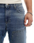 ASOS DESIGN tapered jeans in mid blue wash with carpenter details