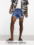 ASOS DESIGN shorter length denim shorts in midwash with rip detail and raw hem