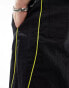 ASOS DESIGN panelled piping track pants in black and yellow sheen nylon