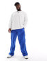 ASOS DESIGN baggy nylon track pants in blue with white piping