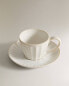 Stoneware teacup and saucer with raised design